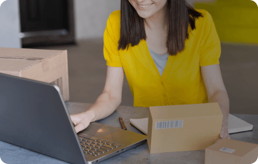 Femme travaillant sur un ordinateur portable avec des colis